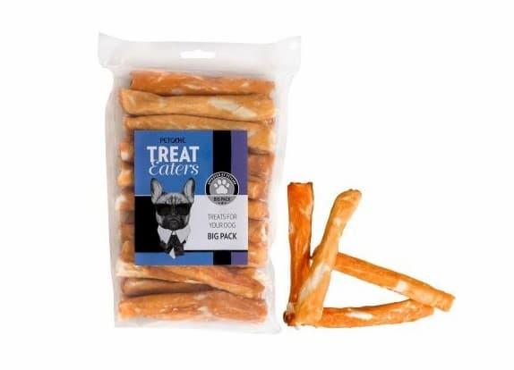 Tyggebein hund test - hund som tygger på et tyggebein på plenen